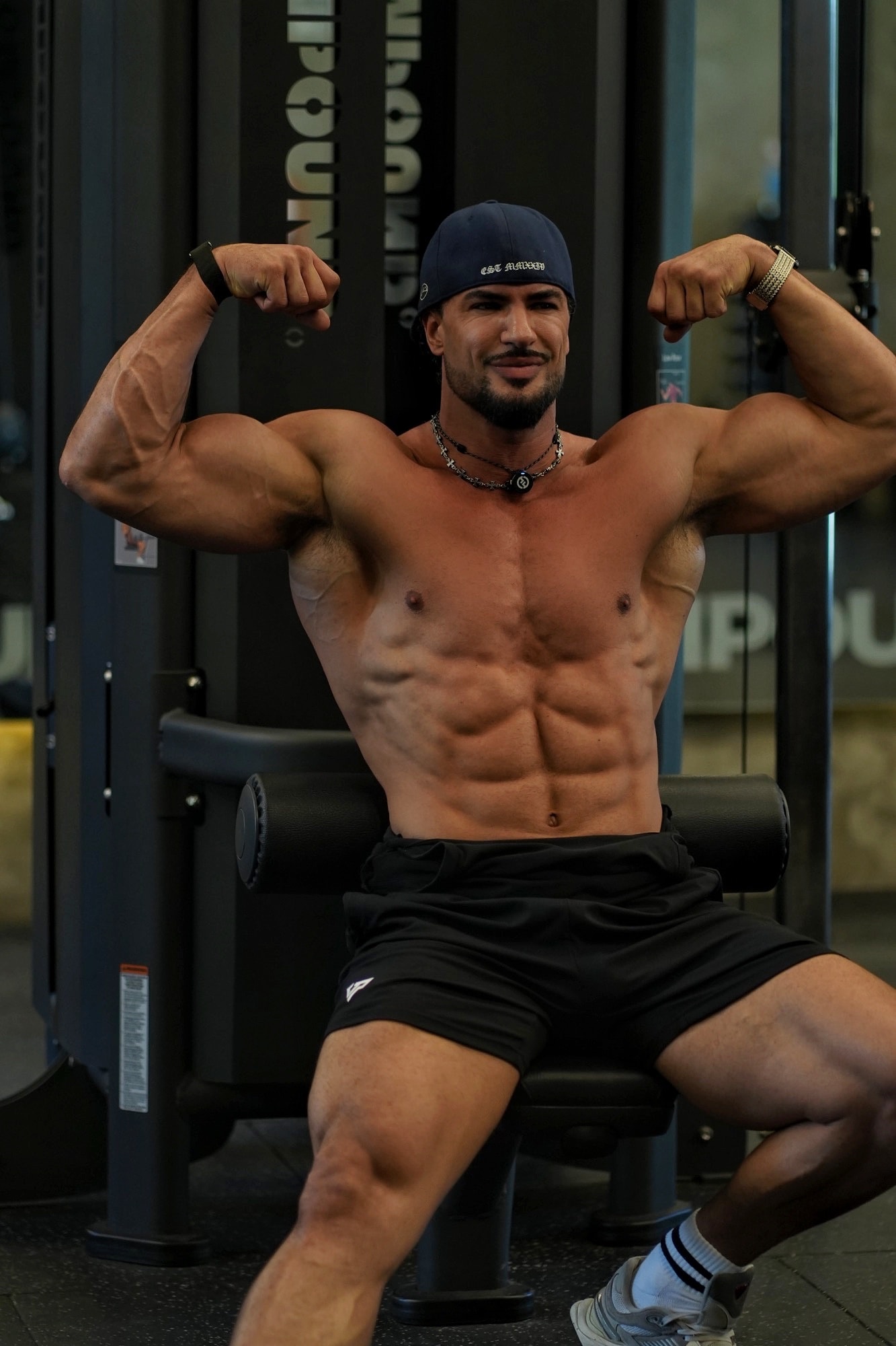 Luis Young flexing biceps in the gym